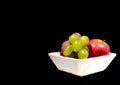 Fruit grape apple plum on a white plate