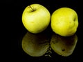 Fruit green apple in drops of water on a black glass background with reflection Royalty Free Stock Photo