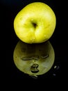 Fruit green apple in drops of water on a black glass background with reflection Royalty Free Stock Photo