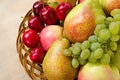 Fruit harvest. Organic fresh apples, pears, grapes and plums in wooden plate Royalty Free Stock Photo