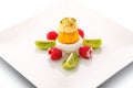 Fruit ice cream with pistachios, kiwi and fresh raspberries on white plate, exclusive summer dessert, patisserie