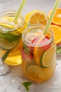 Fruit ice tea and ginger herbal ice tea with mint in glass jars, white background, copy space. Summer refreshing drink concept. Royalty Free Stock Photo