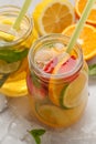 Fruit ice tea and ginger herbal ice tea with mint in glass jars, white background, copy space. Summer refreshing drink concept. Royalty Free Stock Photo