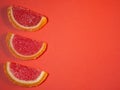 Fruit jelly in the form of orange and grapefruit slices on a red background Royalty Free Stock Photo