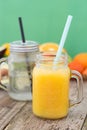 Fruit juice, in glass jar. Green background. Rustic wooden table. Healthy, vegan food and drinks Royalty Free Stock Photo