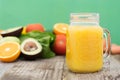 Fruit juice in the glass jar. Green background, wooden table. Fresh vegetables and fruits - avocado, apple, tomatoes. . Healthy, Royalty Free Stock Photo