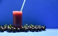 Fruit juice of jabuticaba Myrciaria cauliflora and fresh fruits on blue background