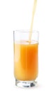 Fruit juice is poured into a glass cup on a white background. Isolated
