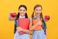 Fruit of knowledge. Happy teen girls with books show apples. Food knowledge