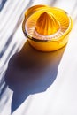 Fruit Lemon Lime Orange Squeezer Manual Hand Press Citrus fruit Juicer Tool. yellow Orange plastic white table sun light Royalty Free Stock Photo