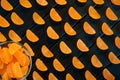 Fruit marmalade in the form of mandarin lobules lies on dark painted boards. The combination of black and orange Royalty Free Stock Photo