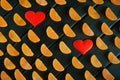 Fruit marmalade in the form of mandarin lobules lies on dark painted boards next to two hearts. The combination of black, orange Royalty Free Stock Photo