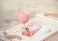 Fruit milkshake, sweet meringue desserts and tender flowers on a wooden coarse tray. light tender still life.