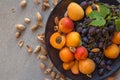 Fruit plate with grapes, apricot and almond on black plate Royalty Free Stock Photo