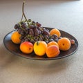 Fruit plate with grapes, apricot and almond on black plate Royalty Free Stock Photo