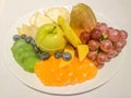 Fruit plate with grapes, orange, apple, pineapple, bluebery, kiwi and mango.