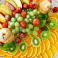 fruit plate with grapes, oranges, kiwis, apples and strawberries