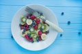 Fruit plate. Kiwi, banana, blueberry and raspberry fruit salad. Wood background Royalty Free Stock Photo