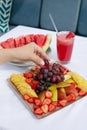 Fruit plate with watermelon, pear, grapes, strawberries, pineapple and fresh juice.