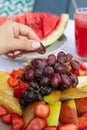 Fruit plate with watermelon, pear, grapes, strawberries, pineapple and fresh juice.