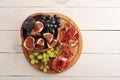 Fruit platter - figs, grapes, pomegranate on wooden background
