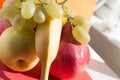 FRUIT PLATTER close-up: golden apple, banana, pomegranate and grapes Royalty Free Stock Photo