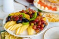 fruit platter. plate with chopped pear, apple, banana, kiwi and grape berries. Royalty Free Stock Photo