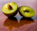 Fruit-plum image. A plum is cut in half. Plum seed. Wooden background. Mature plums fruits Royalty Free Stock Photo