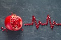 Fruit pomegranate and ECG cardiogram from pomegranate seeds, healthy heart diet concept abstract