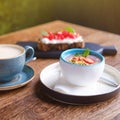 Fruit pudding and cappuccino coffee on a table in a summer restaurant, close up Royalty Free Stock Photo