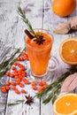 Fruit punch with sea buckthorn berries, citrus and spices in a tall glass