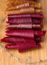 fruit rolls on a wooden board on a black background.