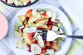 Fruit salad in a ceramic bowl, yogurt.