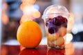 Fruit salad in a clear plastic cup and an orange Royalty Free Stock Photo