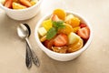 Fruit salad with fresh apple, strawberry, tangerines, pineapple and honey. Diet and healthy eating Royalty Free Stock Photo