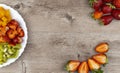 Fruit salad and fresh strawberries on wooden table. healthy and dietary breakfast, food preparation concept Royalty Free Stock Photo