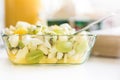 Fruit salad in glass bowl - healthy lunch idea - green grapes, banana, pear, kiwi fruit