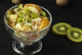 fruit salad in a glass bowl. Kiwi, banana and tangerine with yoghurt