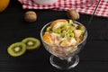 fruit salad in a glass bowl. Kiwi, banana and tangerine with yoghurt