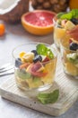 Fruit salad in glasses,  fresh summer foods , healthy organic orange kiwi blueberries pineapple coconut. top view Royalty Free Stock Photo