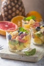 Fruit salad in glasses,  fresh summer foods , healthy organic orange kiwi blueberries pineapple coconut. top view Royalty Free Stock Photo