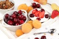 Fruit salad, Healthy breakfast with ingredients, yogurt with granola, strawberries, cherries and peaches on a light table. The Royalty Free Stock Photo