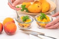 Fruit salad. Mango, peaches, pine nuts and mint leaf close up in a glass bowls