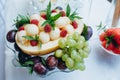 Fruit salad of melon, raspberry, mint, grapes in a glass sundae dish, close up. Royalty Free Stock Photo