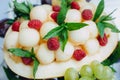 Fruit salad of melon, raspberry, mint, grapes in a glass sundae dish, close up Royalty Free Stock Photo