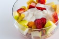 Fruit salad with natural yogurt in glass bowl isolated on white Royalty Free Stock Photo