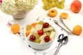 Fruit salad with peach and melon, fresh tropical fruits and berries on a bright sunny table, natural and healthy eating concept, Royalty Free Stock Photo