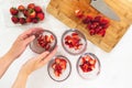 Sliced Strawberries in Clear Glass Bowls, Sliced Strawberries on a Chopping Board, Top View, Woman Hands,  Fruit Salad, Dessert Royalty Free Stock Photo