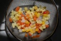 Fruit salad in small pieces in water strainer, wash your fruits before eating, natural background