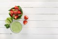 Fruit salad of strawberries, kiwi and pomegranate in a wicker basket and fresh green smoothies with lime and mint in a glass Royalty Free Stock Photo